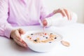 Young woman preparing healthy breakfast muesli at the table. Healthy eating concept Royalty Free Stock Photo