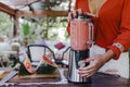 young woman preparing a healthy recipe of diverse fruits, watermelon, orange and blackberries. Using a mixer. Homemade, indoors,