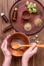 Young woman is preparing homemade mask with clay. A lot of ingredients for home made cosmetics in background Royalty Free Stock Photo