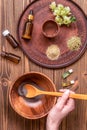 Young woman is preparing homemade mask with clay. A lot of ingredients for home made cosmetics in background Royalty Free Stock Photo