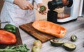 Young woman preparing organic juice with cold pressed extractor machine - Girl making smoothie with vegetables and fruit - Healthy