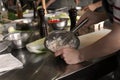 Young woman preparing sauce in restaurant kitchen during cooking classes Royalty Free Stock Photo