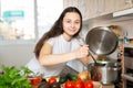 Young woman preparing soup in saucepan in kitchen Royalty Free Stock Photo