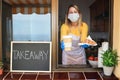 Young woman preparing takeaway breakfast and coffee inside bakery shop while wearing safety mask - Focus on food