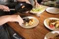 Young woman preparing tasty meat and salad during cooking classes in restaurant kitchen Royalty Free Stock Photo