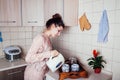 Young woman preparing tea in the kitchen. Pouring water into a cup. Royalty Free Stock Photo