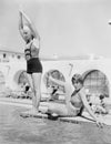 Young woman preparing to dive from a diving platform with another woman sitting beside her