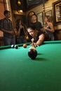 Young woman preparing to hit pool ball. Royalty Free Stock Photo