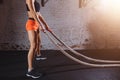 Young woman preparing to working out with battle ropes in cross fit gym Royalty Free Stock Photo