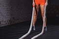 Young woman preparing to working out with battle ropes in cross fit gym Royalty Free Stock Photo