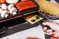 Young woman is preparing a traditional Swiss cheese raclette