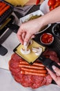 Young woman is preparing a traditional Swiss cheese raclette