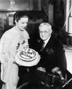 Young woman presenting a birthday cake to an elderly man Royalty Free Stock Photo