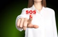 Young woman pressing virtual SOS button in case of danger on green background, closeup Royalty Free Stock Photo