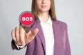 Young woman pressing virtual SOS button in case of danger on grey background, closeup Royalty Free Stock Photo