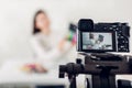 Young woman professional beauty vlogger or blogger recording make up tutorial using camera and tripod Royalty Free Stock Photo