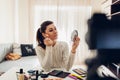 Young woman professional beauty vlogger or blogger recording make up tutorial using camera and tripod Royalty Free Stock Photo