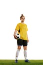 Young woman, professional female football, soccer player in yellow uniform posing with ball isolated over white studio Royalty Free Stock Photo