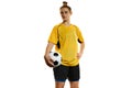 Young woman, professional female football, soccer player in yellow uniform posing with ball isolated over white studio Royalty Free Stock Photo