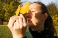 Young woman in profile with yellow leaves, sunlight, shadows, hands close up, autumn inspiration Royalty Free Stock Photo