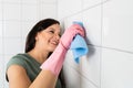 Woman Cleaning The White Tile Of The Wall Royalty Free Stock Photo