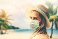 Young woman with protective face mask at tropical beach. covid-19 or coronavirus pandemic. summer travel with new normal