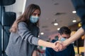 Young woman in a protective mask shaking hands with her colleague. Royalty Free Stock Photo