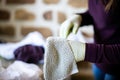 Young woman in protective rubber gloves cleaning bright light-toned tiled wall at home Royalty Free Stock Photo