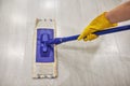 Girl in protective gloves cleaning floor using flat wet mop Royalty Free Stock Photo