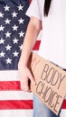 Young woman protester holds cardboard with My Body My Choice sign against USA flag on background. Girl protesting against anti- Royalty Free Stock Photo