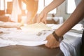 Young woman pull out paper from waterproof film on fabric at shop. worker working on manual screen printing on t-shirt.