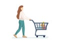 Young woman purchaser carrying supermarket shopping cart full of groceries. Female buyer pushing grocery store basket Royalty Free Stock Photo