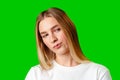 Young Woman With Pursed Lips Expressing Skepticism Against Green Screen Background