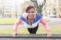 Young woman push up on the wood bench.