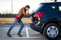 Young woman pushing car