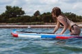 Young woman pushing a sup board in the sea. Healthy and fit life in the nature.