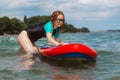 Young woman pushing a sup board in the sea. Healthy and fit life in the nature.