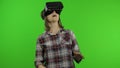 Young woman using VR headset helmet to play game. Watching virtual reality 3d 360 video. Chroma key Royalty Free Stock Photo