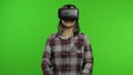 Young woman using VR headset helmet to play game. Watching virtual reality 3d 360 video. Chroma key Royalty Free Stock Photo