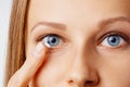 Young woman puts contact lens in her eye. Eyewear, eyesight and vision, eye care and health, ophthalmology and optometry concept Royalty Free Stock Photo