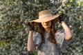 Young woman puts on or takes off her straw hat with hands in black vintage lace gloves. Cottagecore aesthetics. Royalty Free Stock Photo