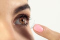 Young woman putting contact lens in her eye Royalty Free Stock Photo