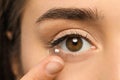 Young woman putting contact lens in her eye, closeup Royalty Free Stock Photo