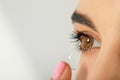 Young woman putting contact lens in her eye, closeup. Space for text Royalty Free Stock Photo