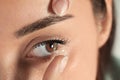 Young woman putting contact lens in her eye Royalty Free Stock Photo