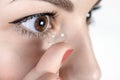 Young woman putting contact lens in her right eye, close up Royalty Free Stock Photo