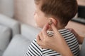 Young woman putting hearing aid in little son`s ear, closeup Royalty Free Stock Photo