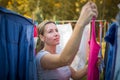 Young woman putting laundry on a rope in her garden Royalty Free Stock Photo