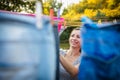 Young woman putting laundry on a rope in her garden Royalty Free Stock Photo