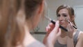 Young Woman Putting Makeup on Face in Mirror Royalty Free Stock Photo